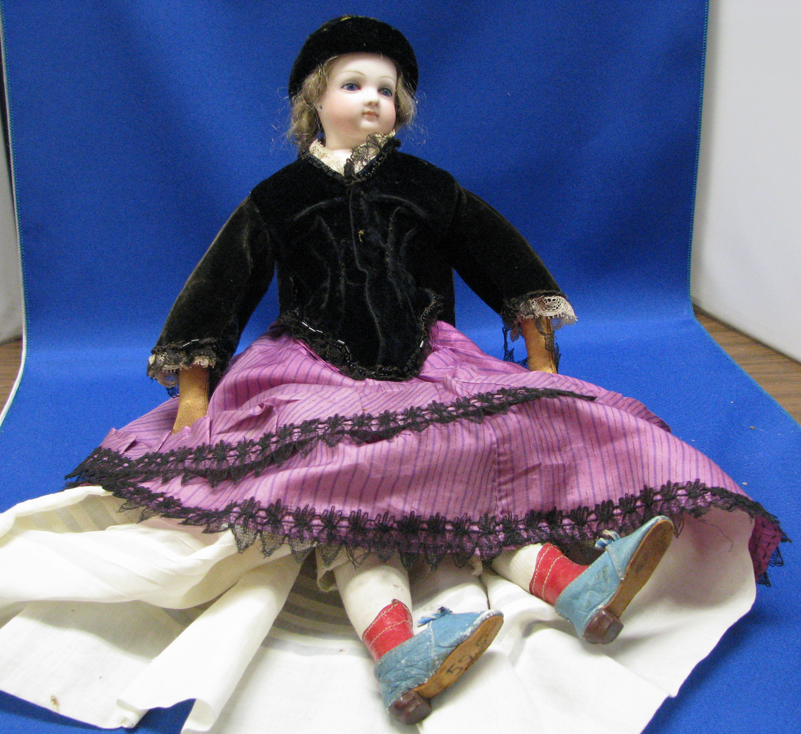 a%20toy%20cotton%20doll%20with%20blond%20hair%2C%20black%20sweather%20and%20purple%20skirt